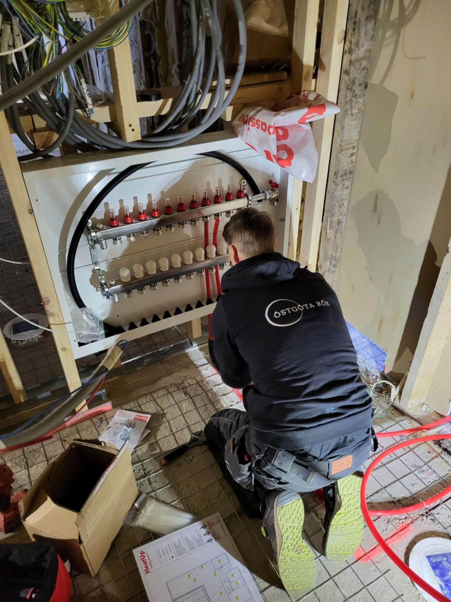 VVS-montör från Östgöta Rör installerar golvvärmefördelare i ett pågående byggprojekt